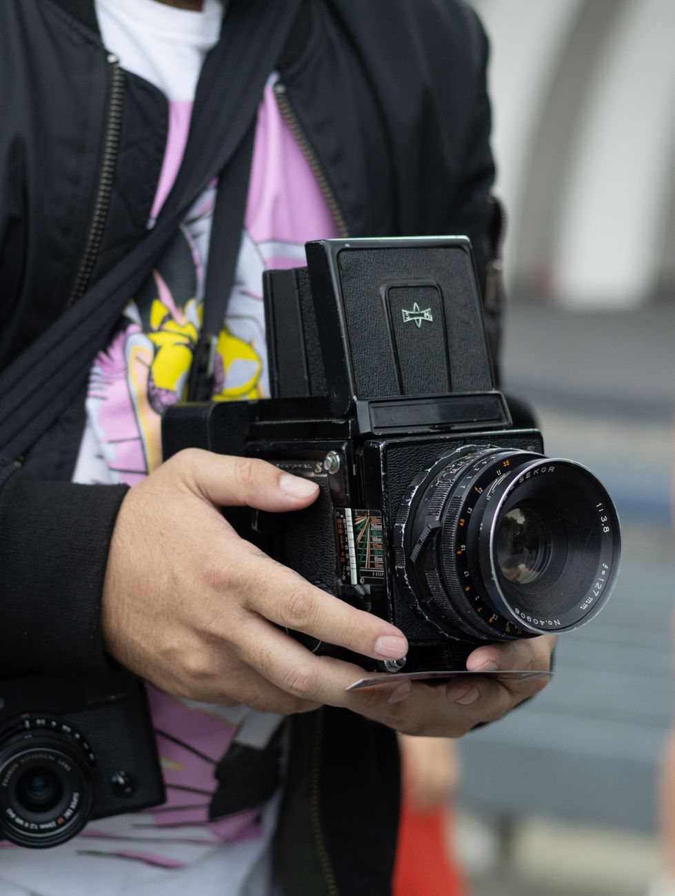 Close-up of a person holding a classic medium format camera.
